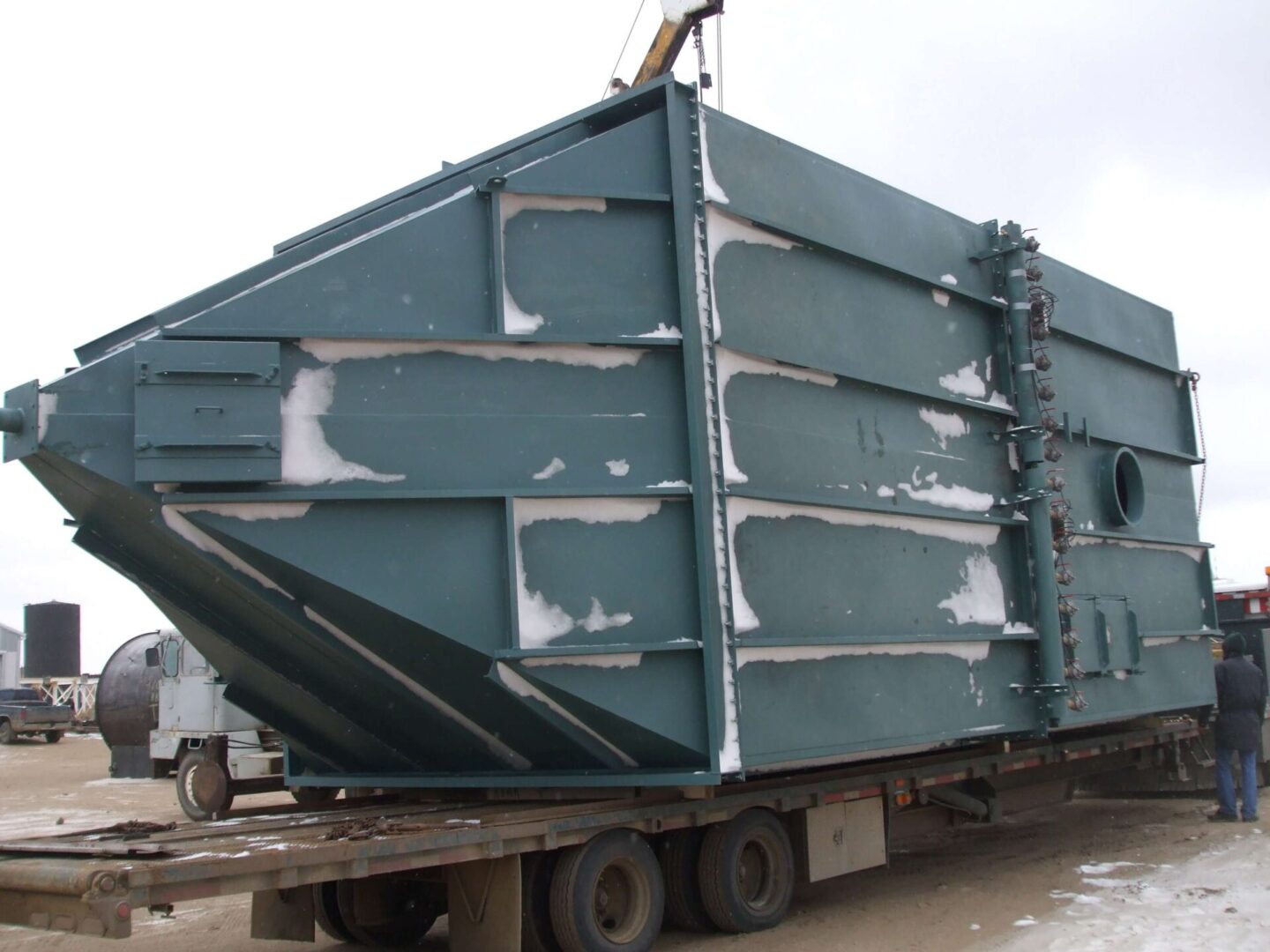 A large green container on a flatbed truck.