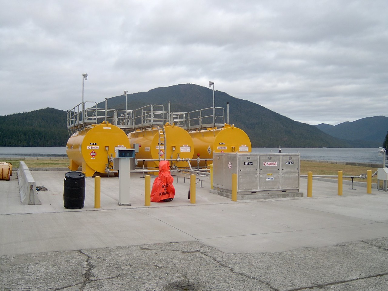 A large yellow tanks on a concrete surface.